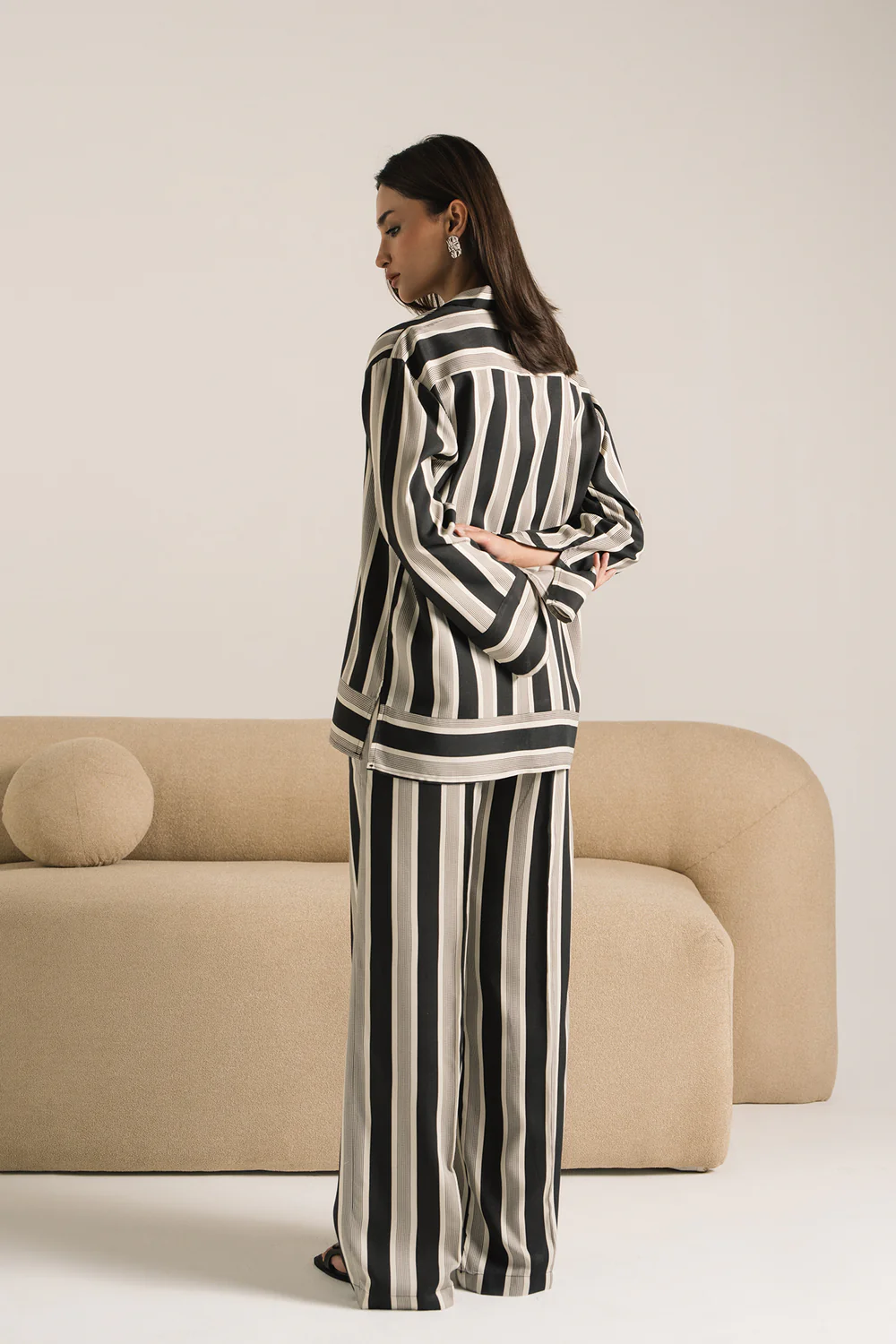 Lifestyle view showcasing the crisp collar and sweeping flared trousers of the monochromatic striped matching set.