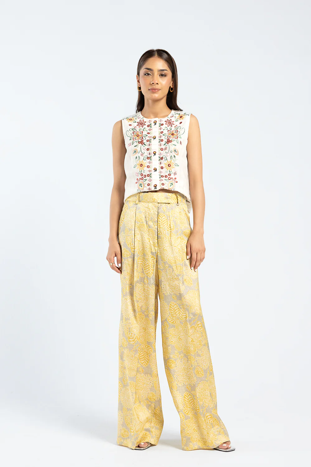 Front studio portrait of Biljiki bright yellow floral flared trousers on a 5'6 model.