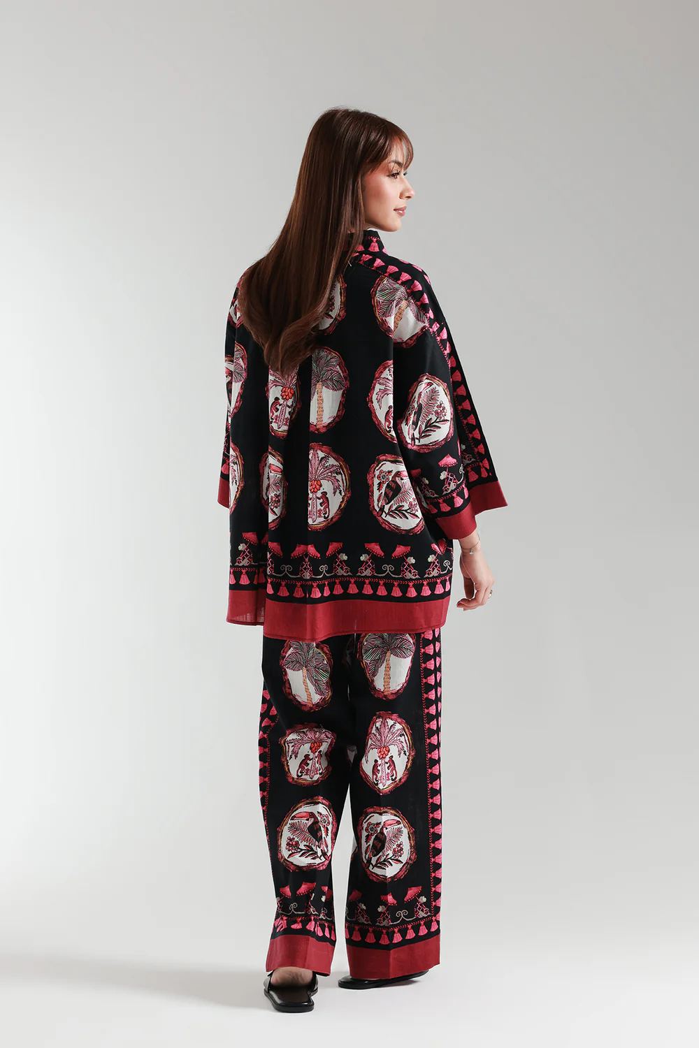 Lifestyle view showcasing the quarter bell sleeves and straight culotte trousers of the dark botanical matching set.