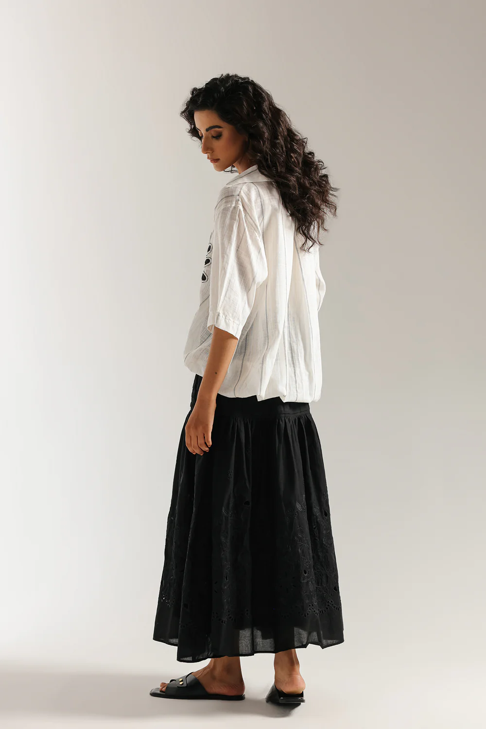Back studio portrait of Biljiki jet black tiered blouse featuring a vibrant polychrome collage print on a 5'6 model.