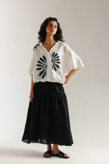 Front studio portrait of Biljiki jet black tiered blouse featuring a vibrant polychrome collage print on a 5'6 model.