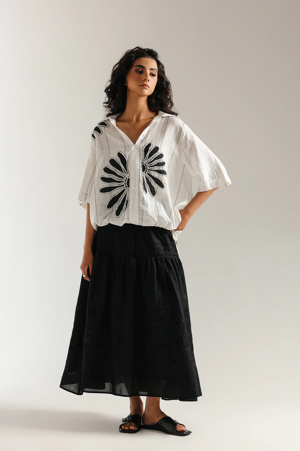 Front studio portrait of Biljiki jet black tiered blouse featuring a vibrant polychrome collage print on a 5'6 model.