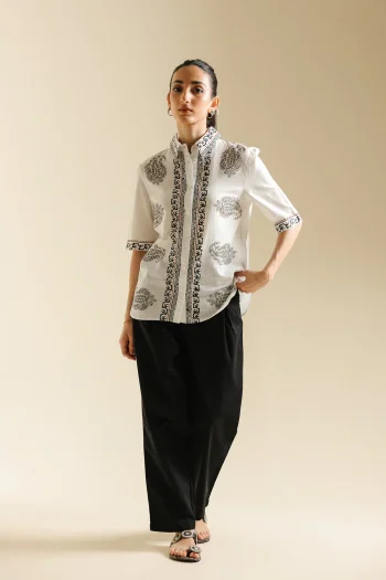 Front studio portrait of Biljiki jet black relaxed-fit pleated trousers on a 5'6 model.