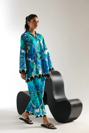 Lifestyle view showcasing the architectural A-line hem of the short shirt and the straight culotte trousers of the contemporary matching set.