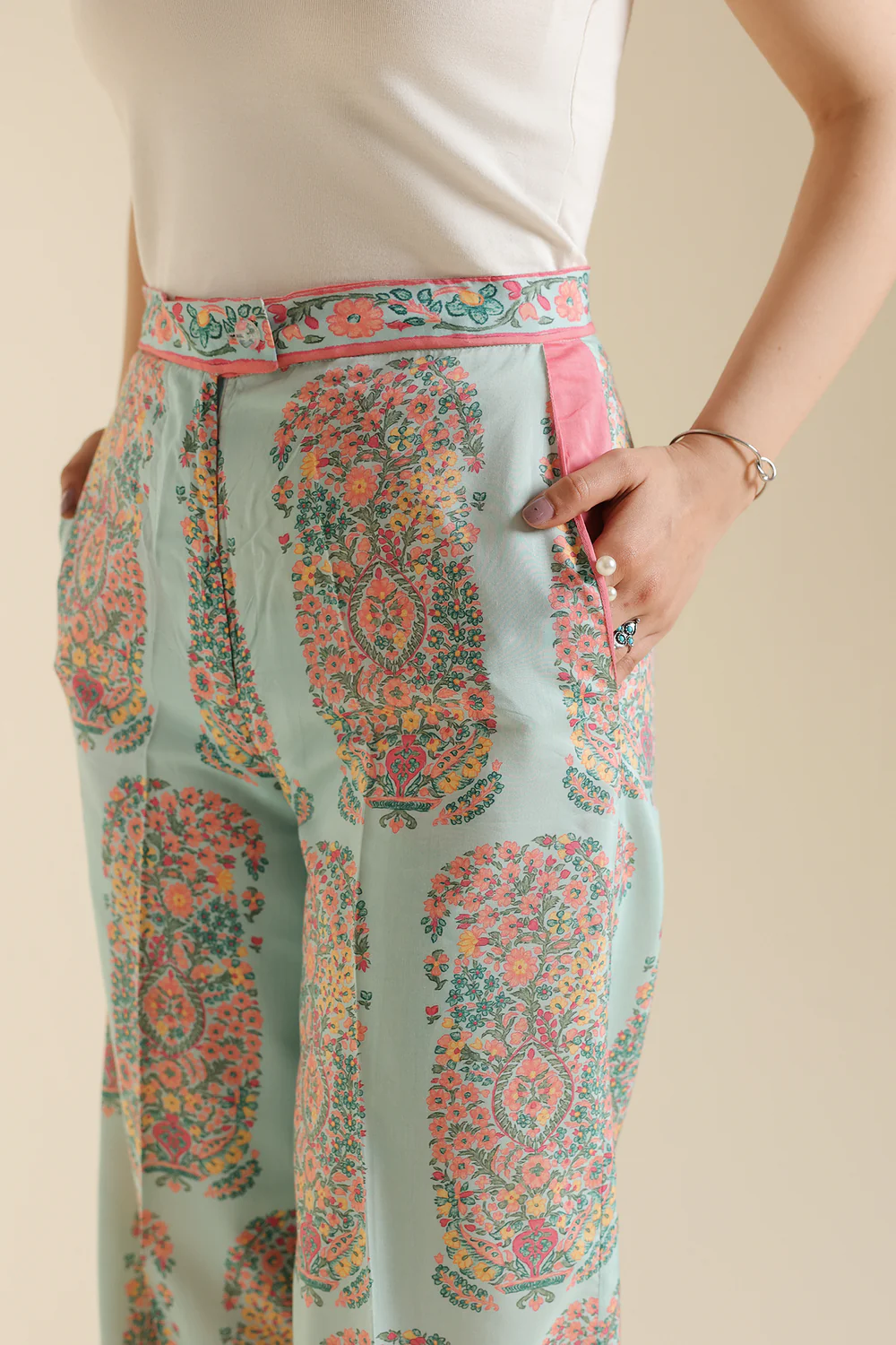 Lifestyle view showcasing the clean tailored silhouette and elegant drape of the contemporary printed pink trousers.