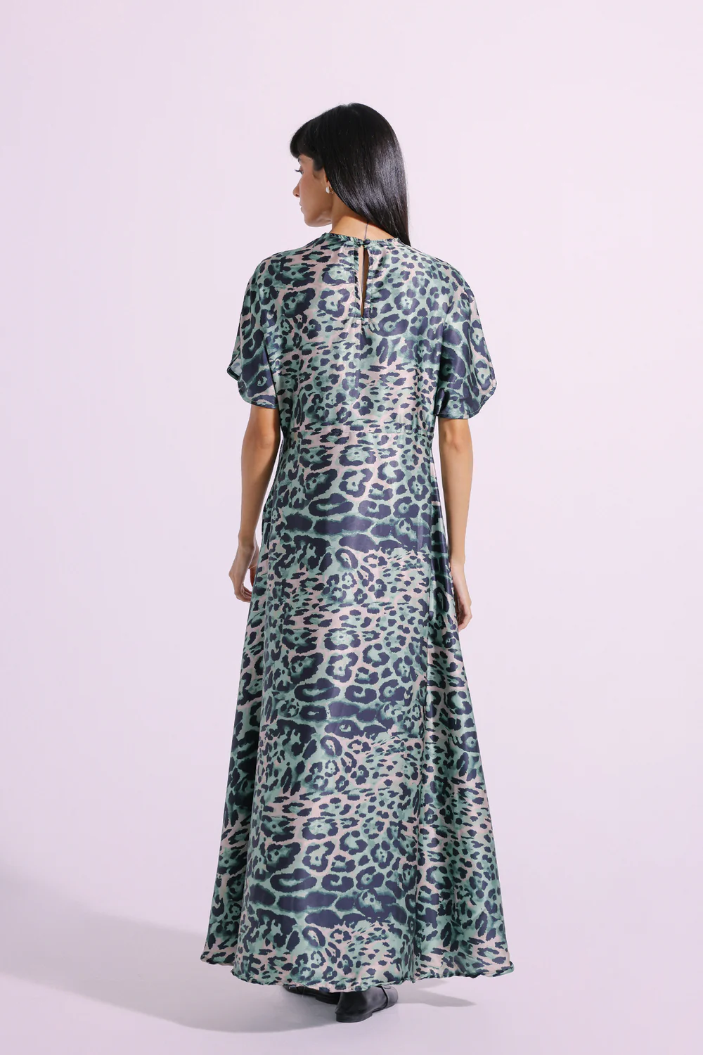 Back studio portrait of Biljiki verdant green animal printed elongated maxi dress on a 5'6 model.