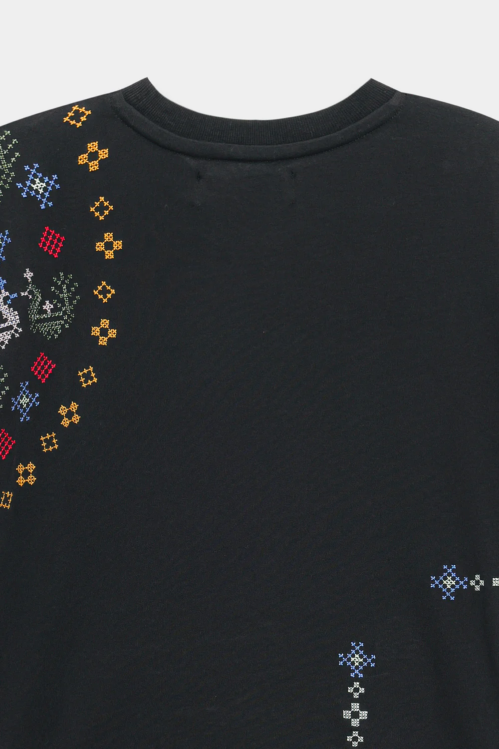 Close-up shot highlighting the intricate, multi-colored geometric and abstract threadwork on the premium deep black textile.