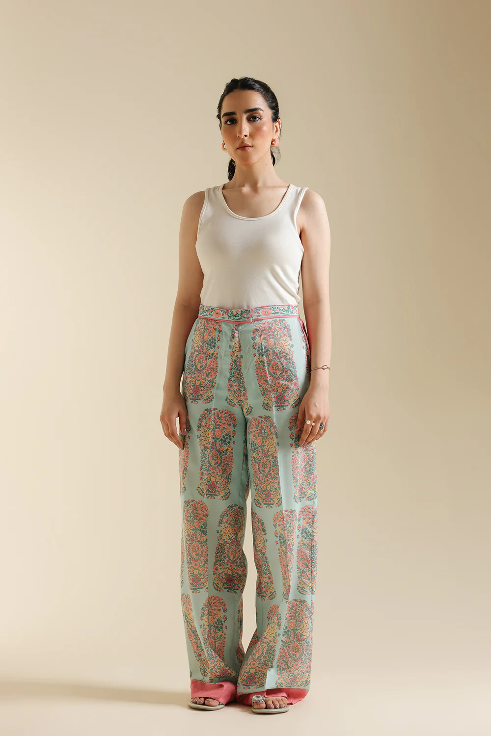 Front studio portrait of Biljiki pale pink contemporary trousers featuring a vibrant paisley print on a 5'6 model.