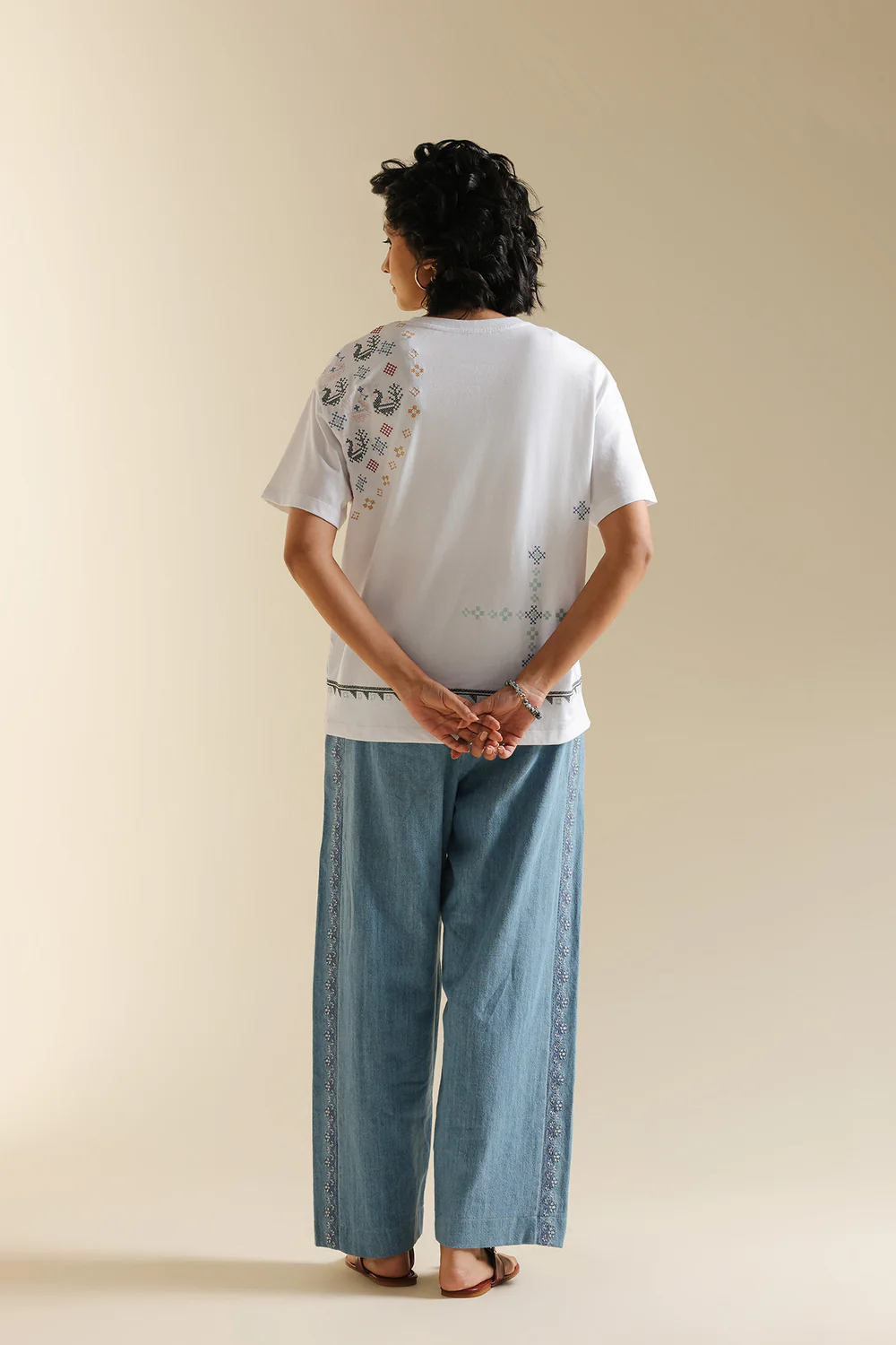 Back studio portrait of Biljiki optic white t-shirt featuring multi-colored abstract embroidery on a 5'6 model.