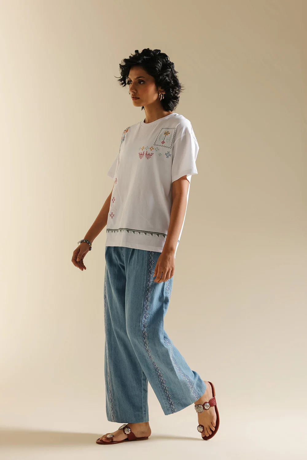 Front studio portrait of Biljiki optic white t-shirt featuring multi-colored abstract embroidery on a 5'6 model.