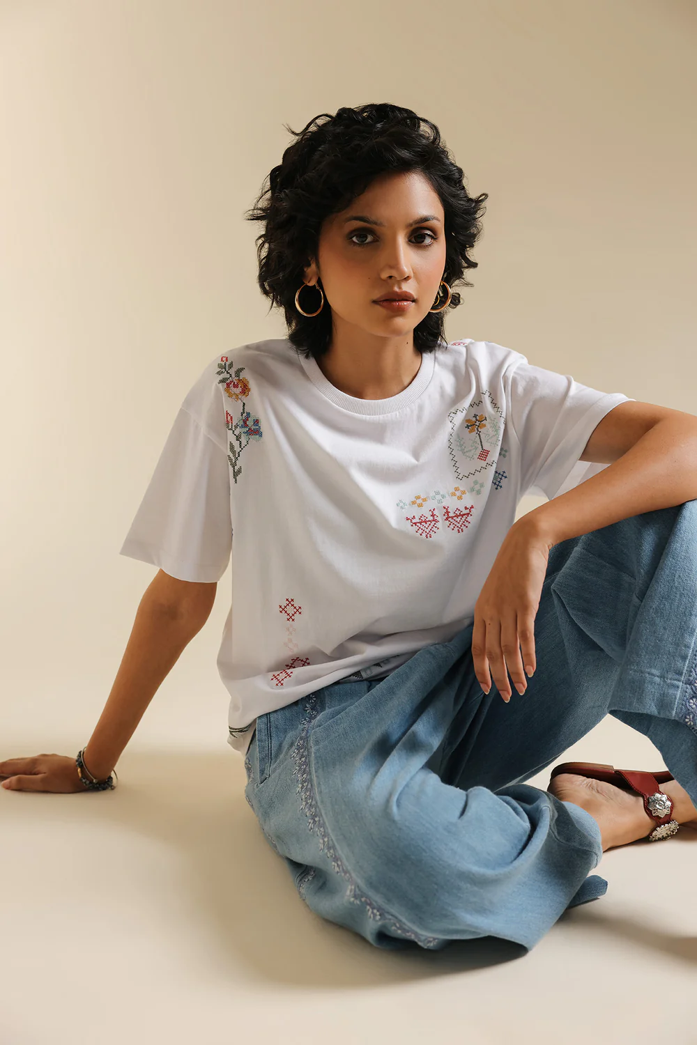 Lifestyle view showcasing the relaxed fit and contemporary drape of the abstract embroidered white t-shirt.