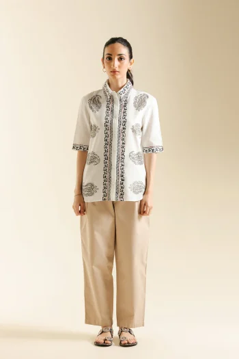 Front studio portrait of Biljiki crisp white short-sleeved kurti featuring black and brown geometric prints on a 5'6 model.