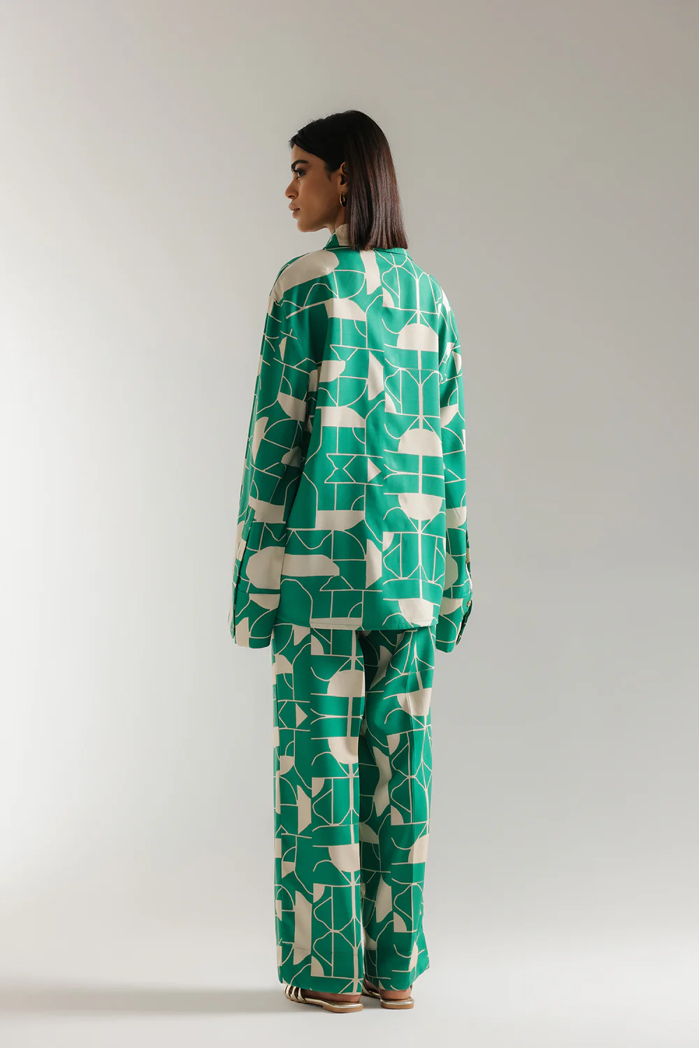 Back studio portrait of Biljiki verdant green optical illusion printed two-piece set on a 5'6 model.