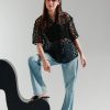 Front view of black cutwork net button-down women’s top