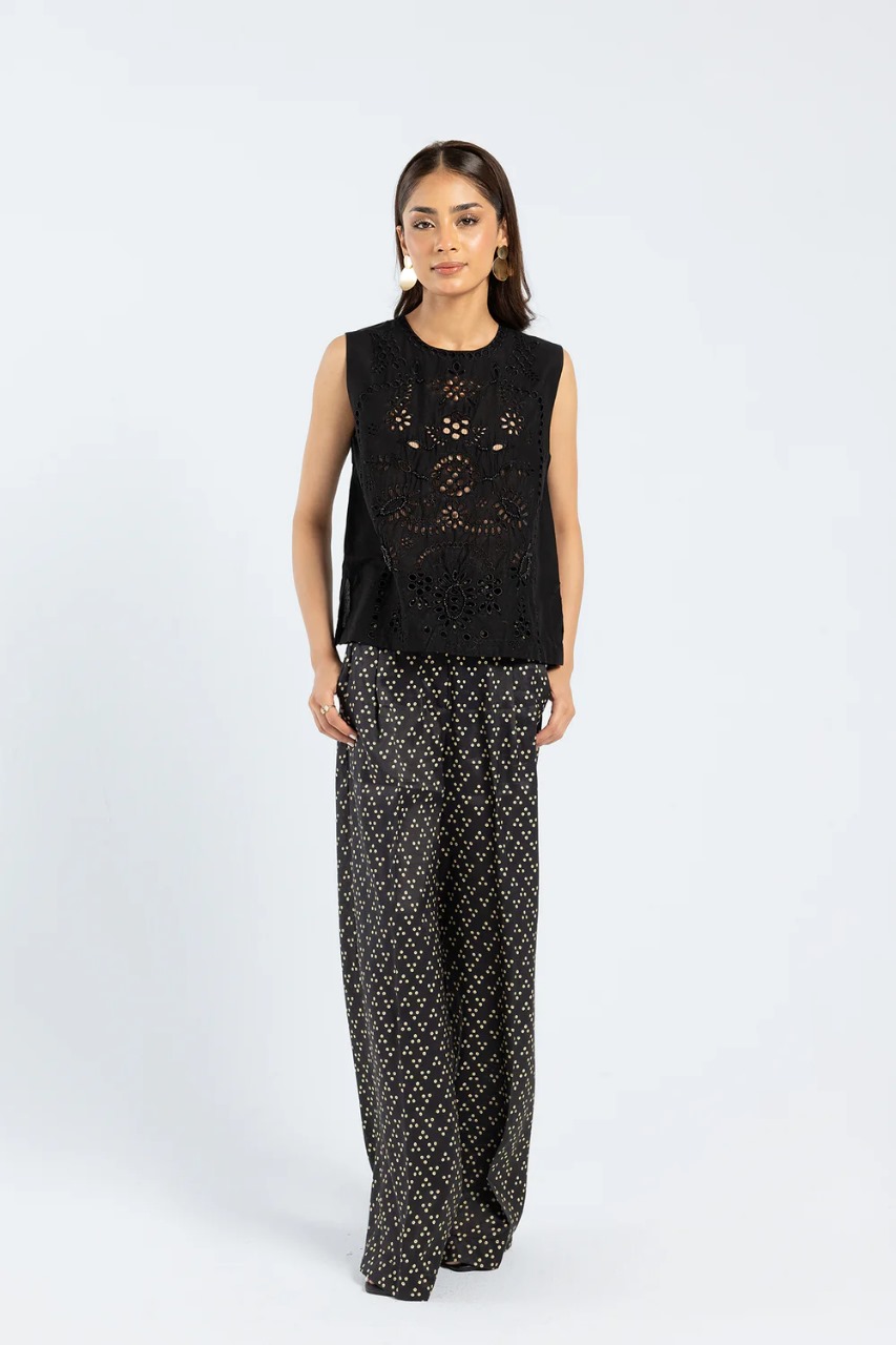 Model wearing jet black sleeveless embroidered kurti with schiffli details