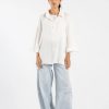 Model wearing white button-down shirt in viscose linen