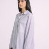 Model wearing grey striped button-down shirt with beaded pocket